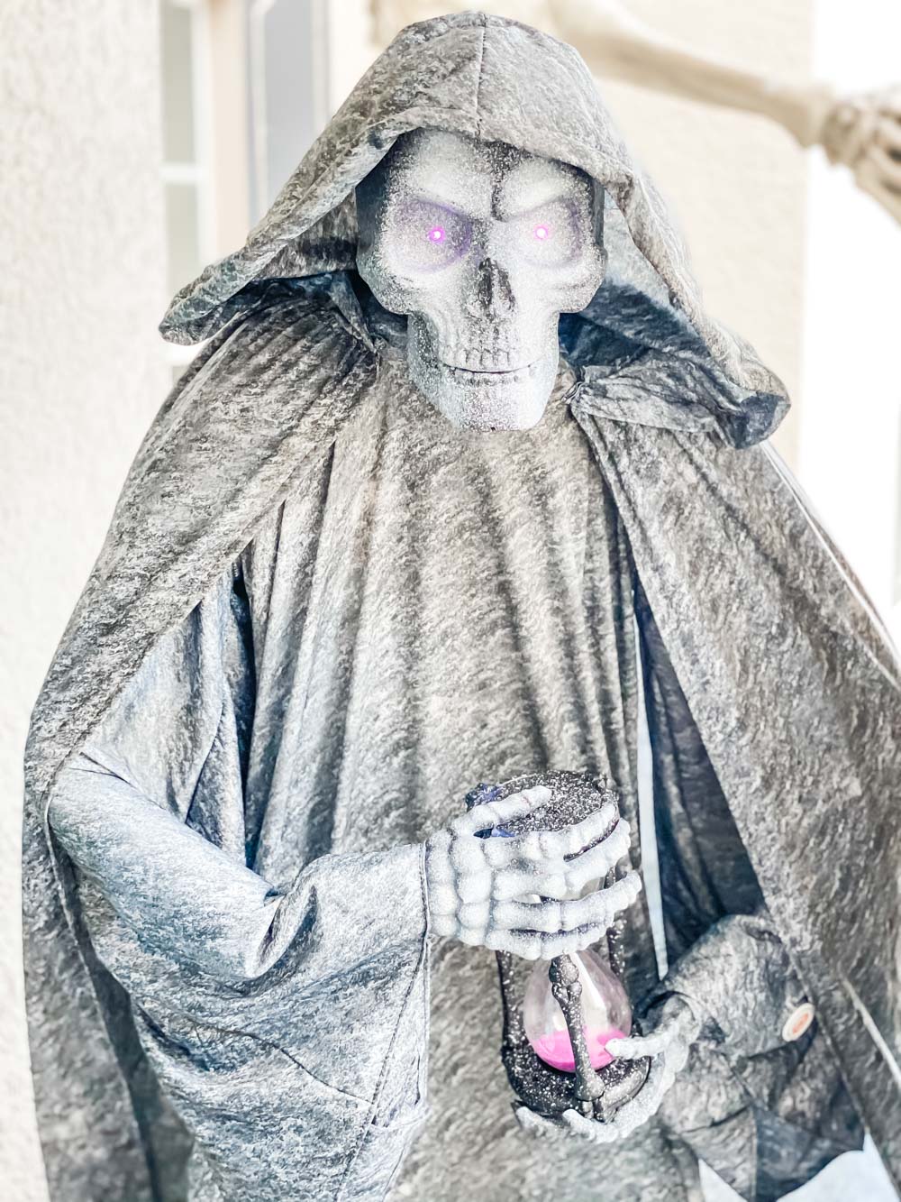 A spooky cemetery statue with glowing purple eyes.