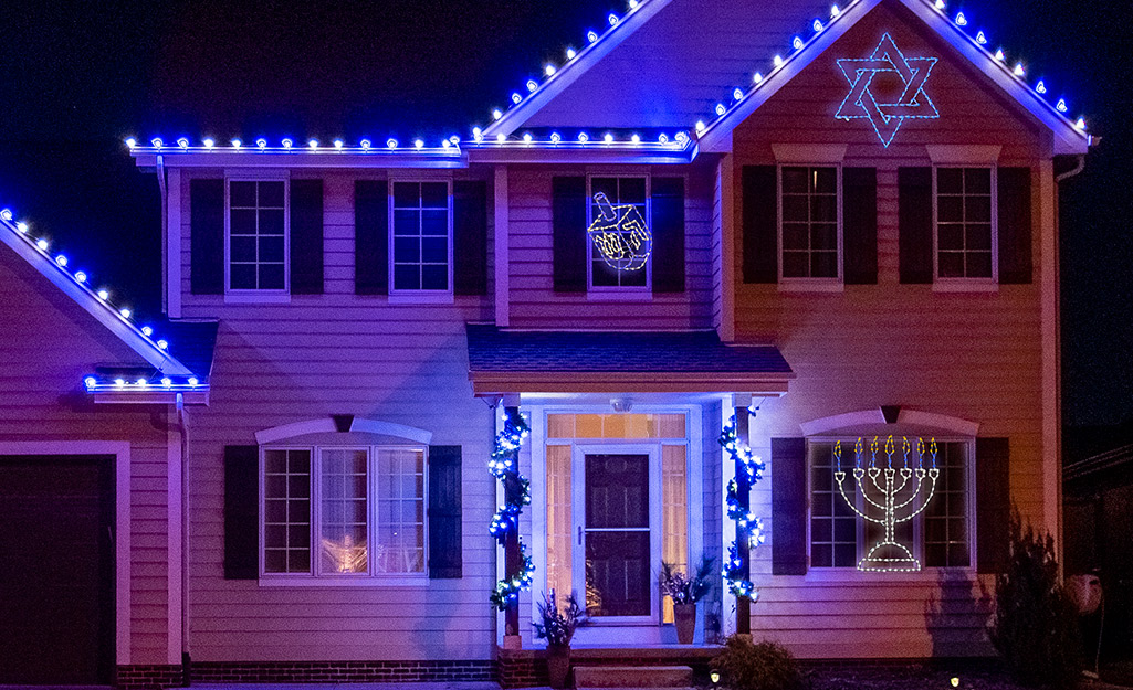 A Happy Hanakkuh holiday light display decorated with stars.