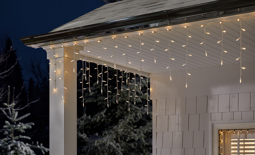 Weeping lights hanging from the eaves of a porch.