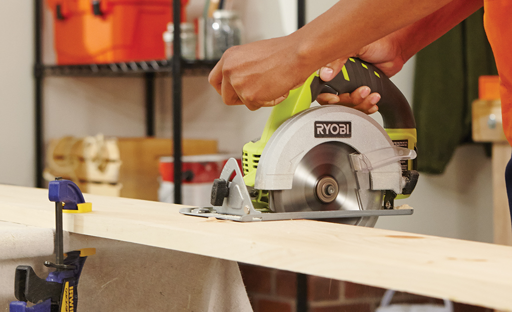 a person using a saw to cut plywood a person using a saw to cut plywood