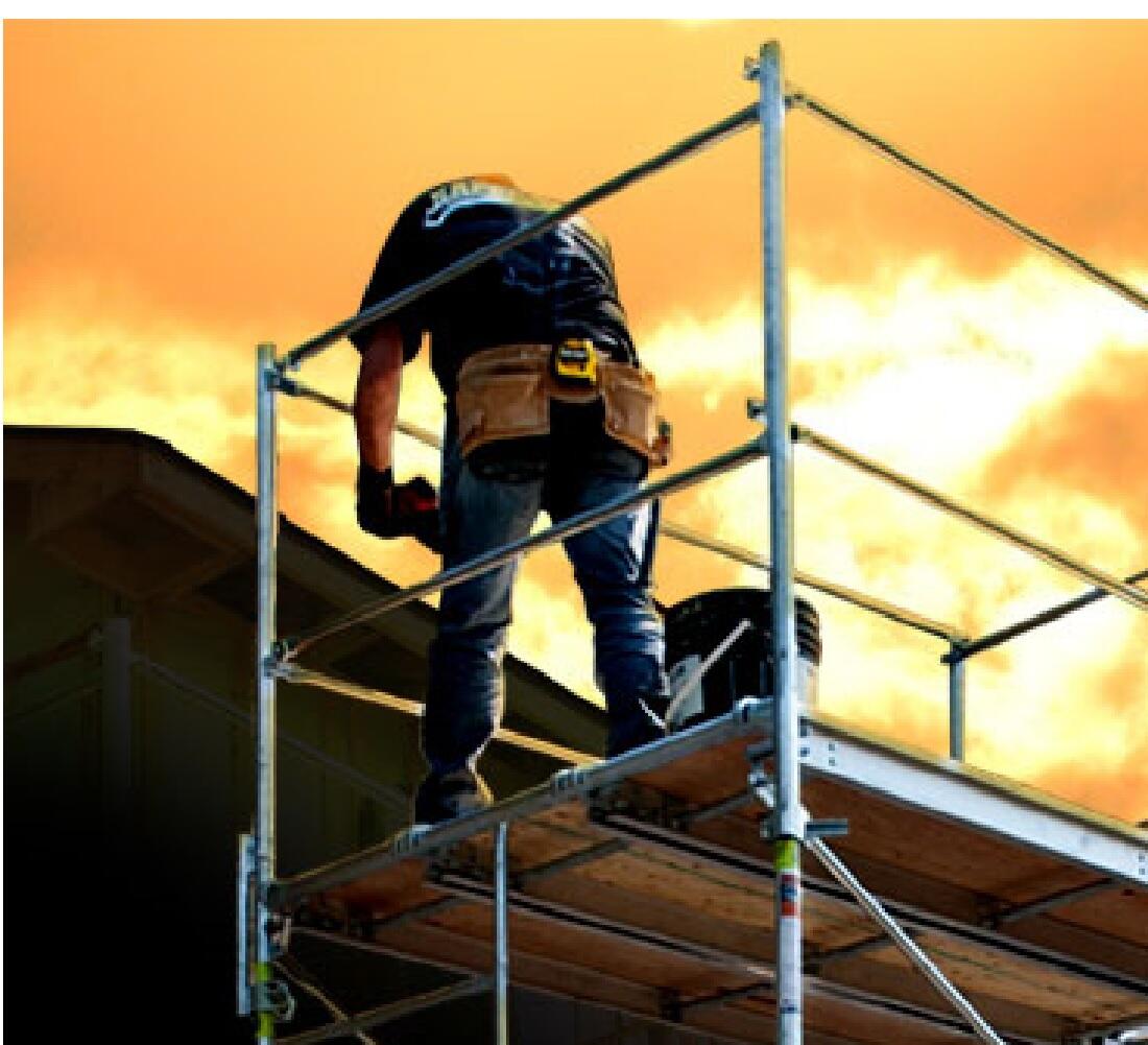 A Construction Worker Stands on a Platform