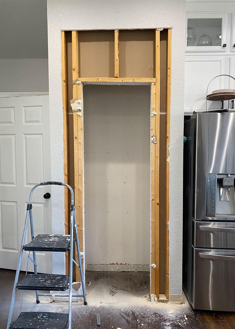Open door frame with exposed wood beams with a step stool placed in front
