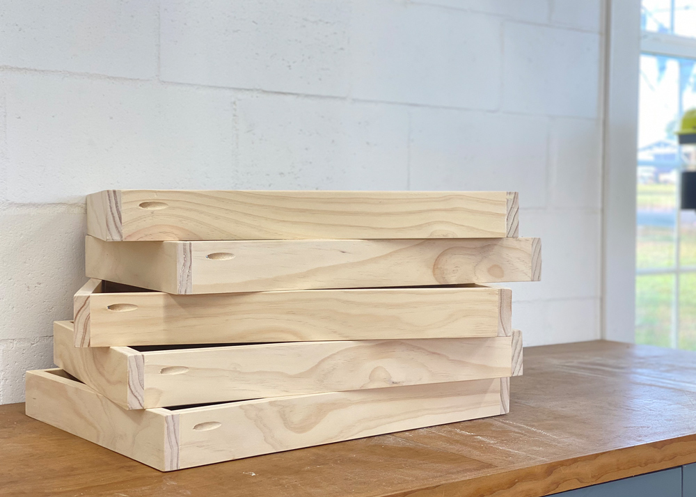 Five wooden shelves stacked on top of each other on a table top
