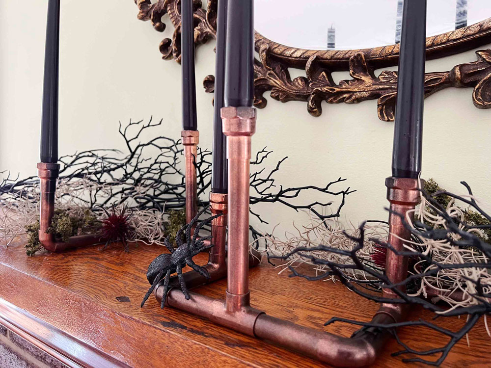 Creepy candles are displayed on a tabletop in front of a scary decorated mirror. Creepy candles are displayed on a tabletop in front of a scary decorated mirror.