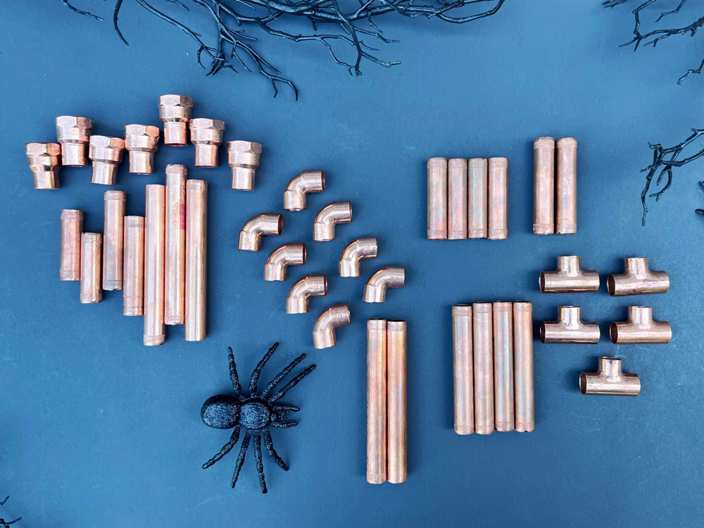 Copper materials laid out on table with a fake spider for decoration.