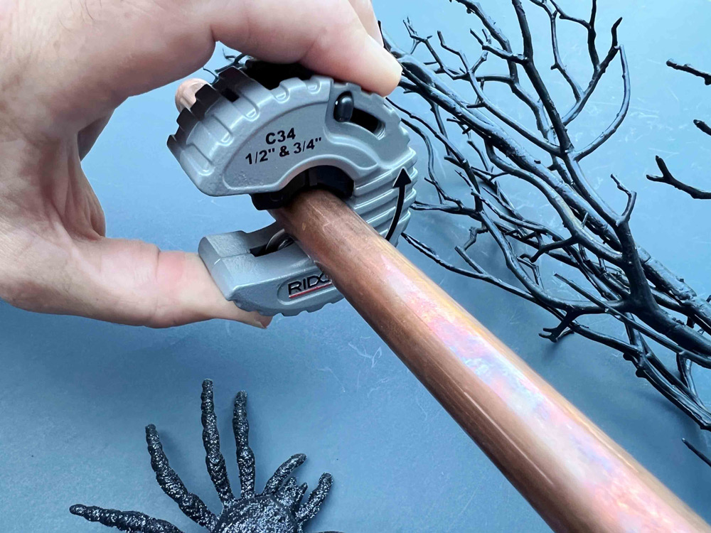 Measure twice, cut once. A hand holding a Ridgid copper pipe cutter.