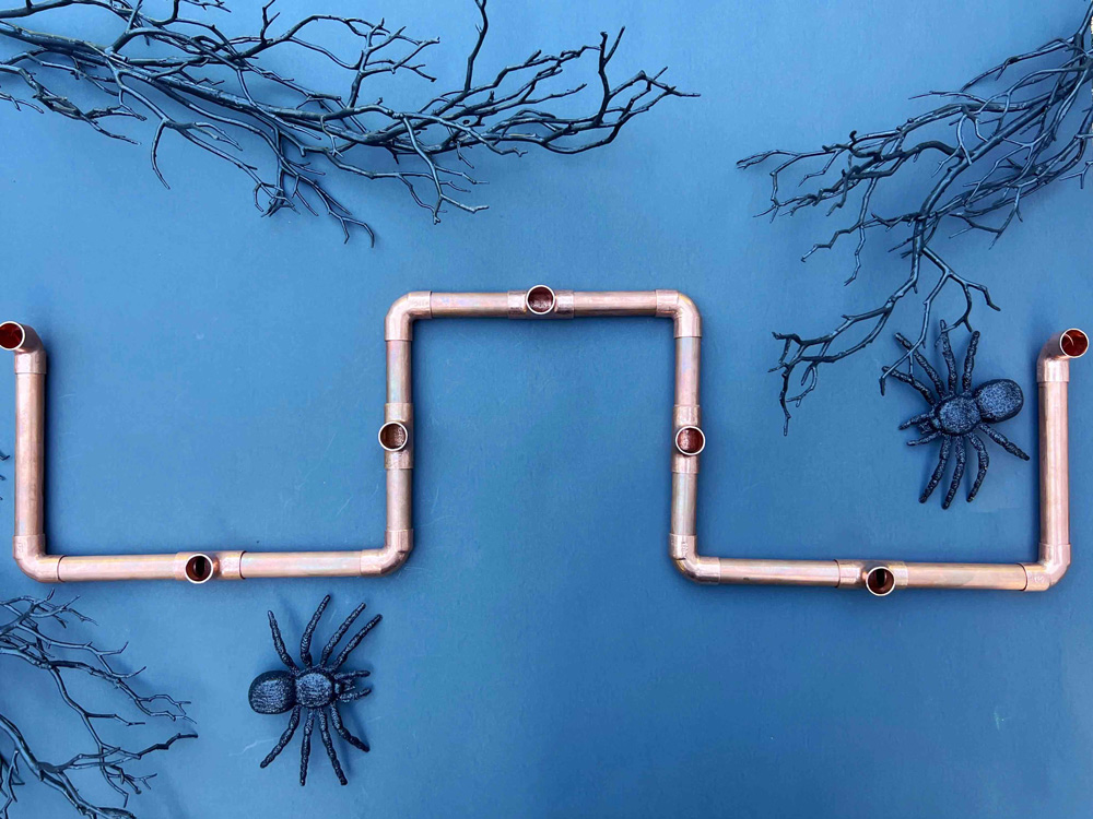 Copper piping laid together to create candle holders. Copper piping laid together to create candle holders.