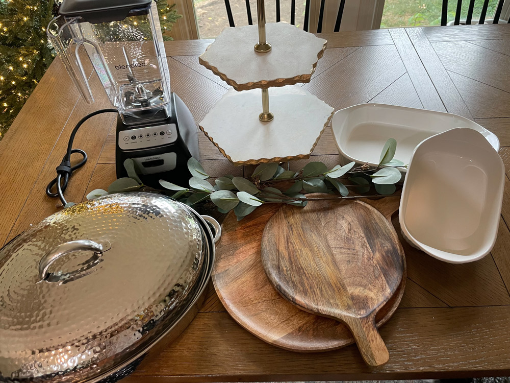 Blender, serving boards, and trays on a dining room table.