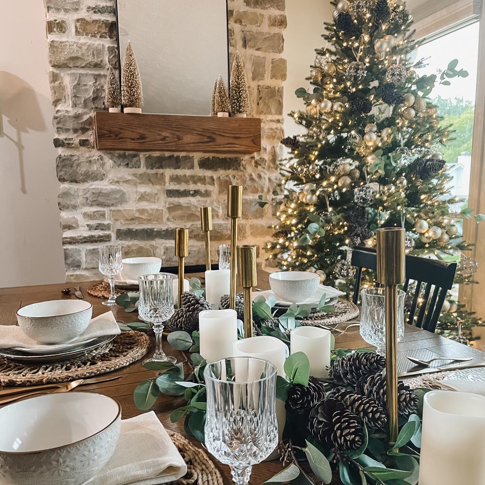Dining room table set with Christmas tree in the background.