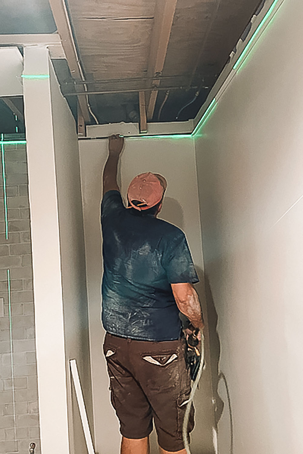 Man adjusting LED lighting to fit the wall in the laundry room. Man adjusting LED lighting to fit the wall in the laundry room.