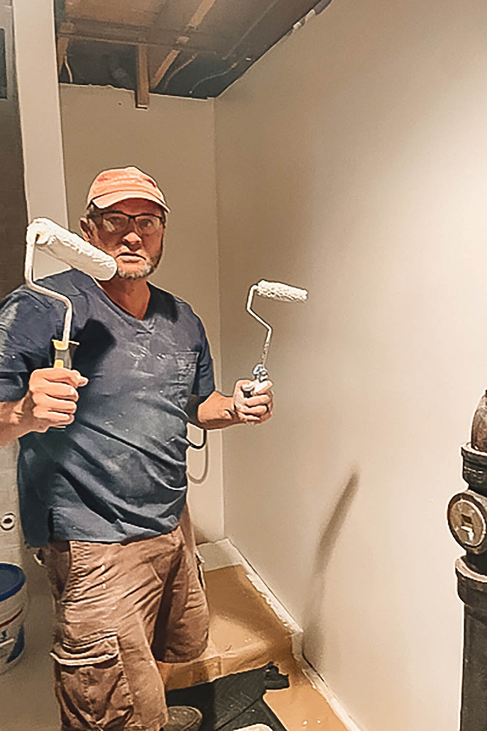 Man holding two paint rollers, one in each hand. Man holding two paint rollers, one in each hand.