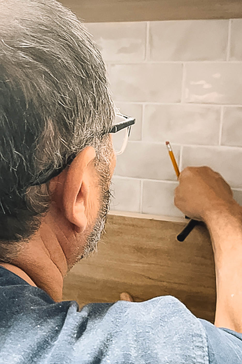 Man measuring for shelf placement. Man measuring for shelf placement.