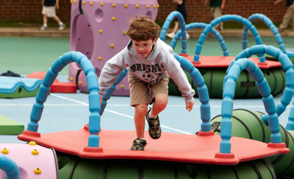 A boy on a playground play system.
