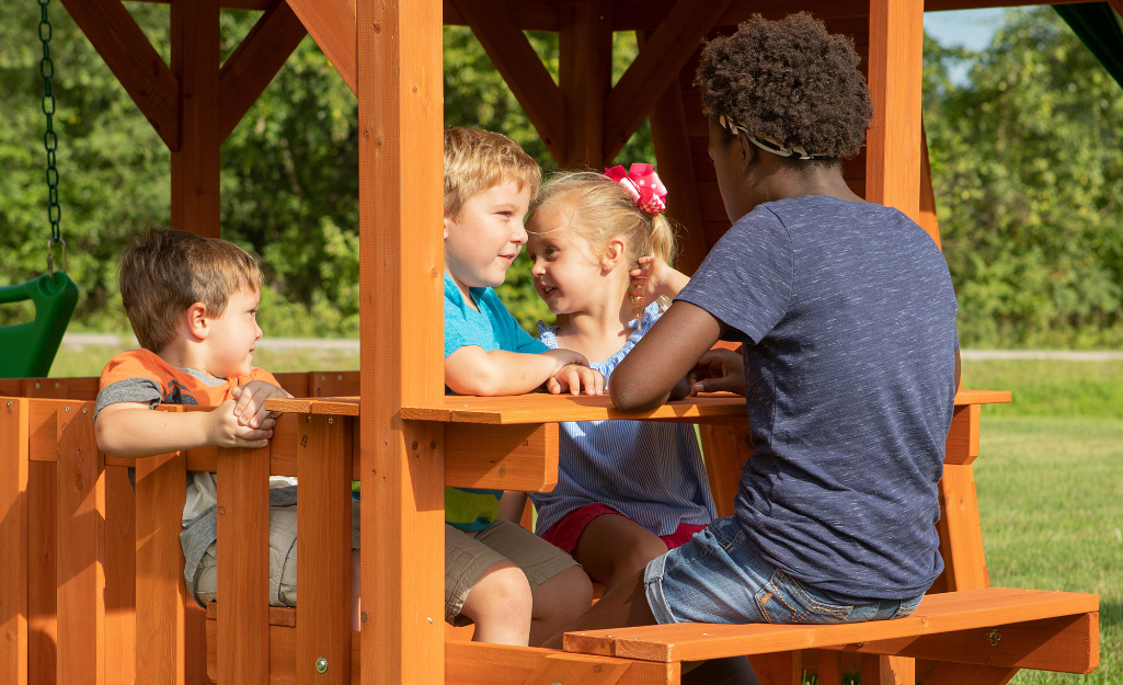 Children sit at a playground table.