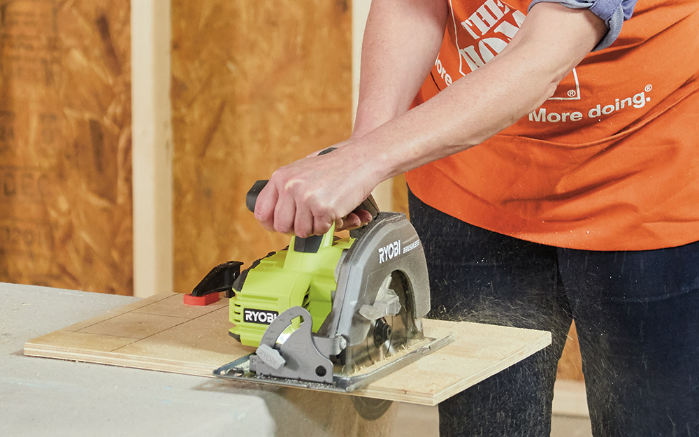 A woman cutting wood with a circular saw. A woman cutting wood with a circular saw.