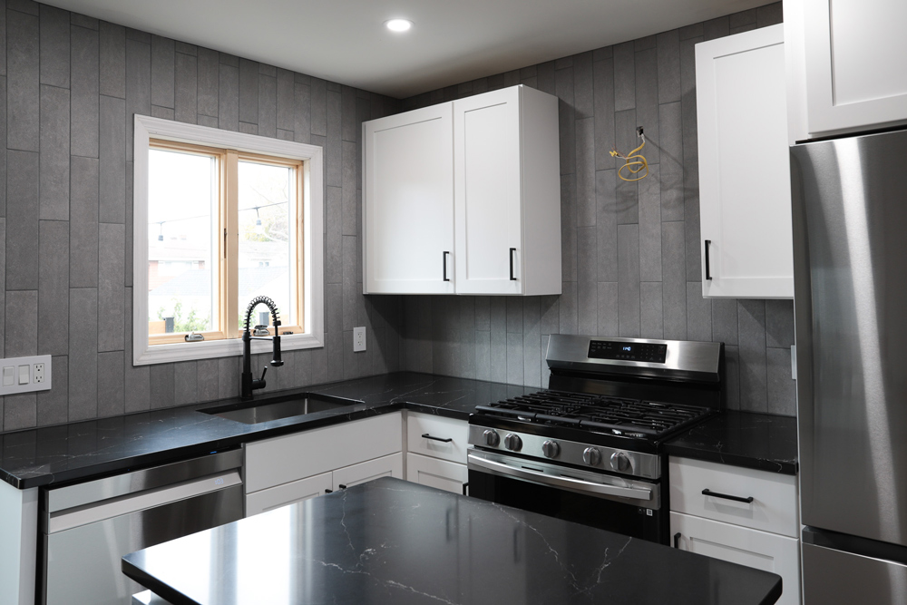 Full view of a kitchen with completed gray tiling.