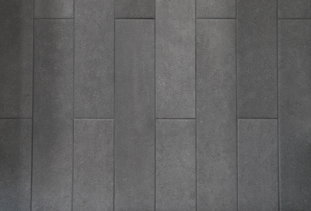 Close-up of completed gray tile with dark grout.