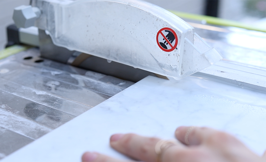 A person cutting tile with a tile saw.