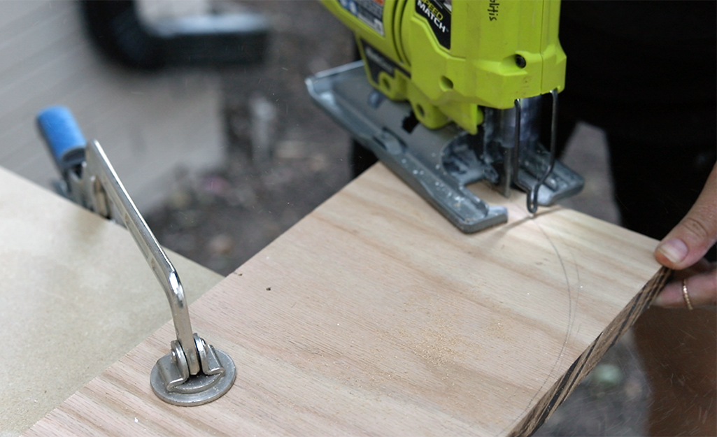 A person cutting out wood with a jig saw.