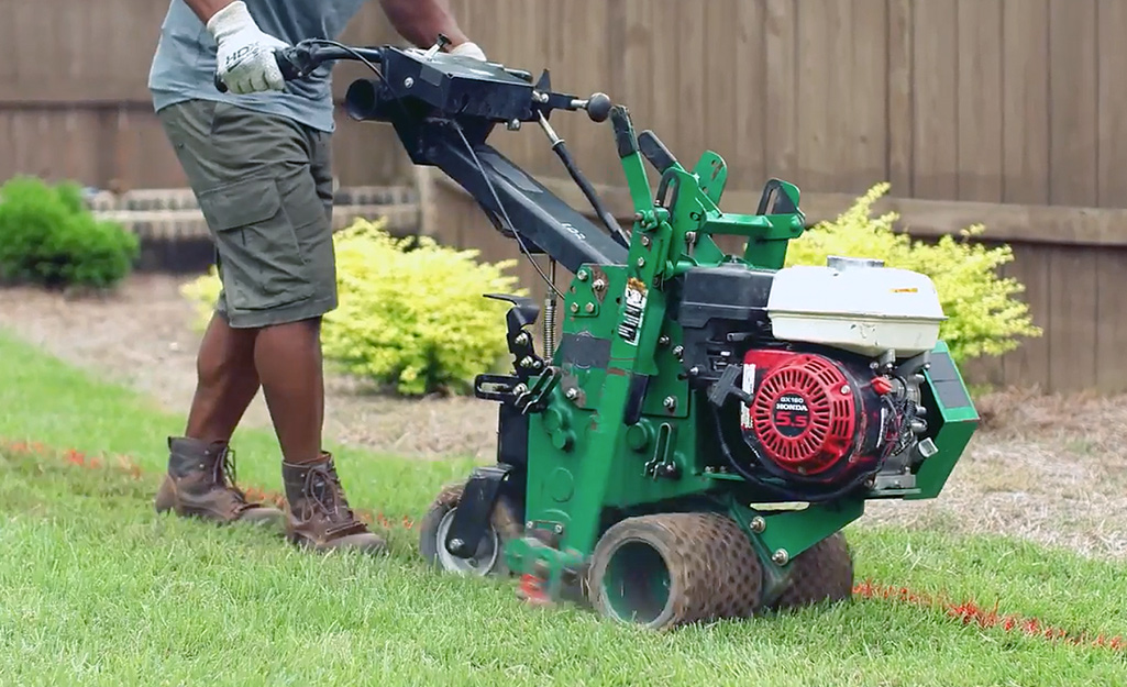 A person removing sod from the ground to make a putting green.