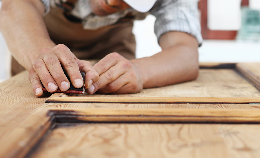 A worker installs the wood pattern on a door.