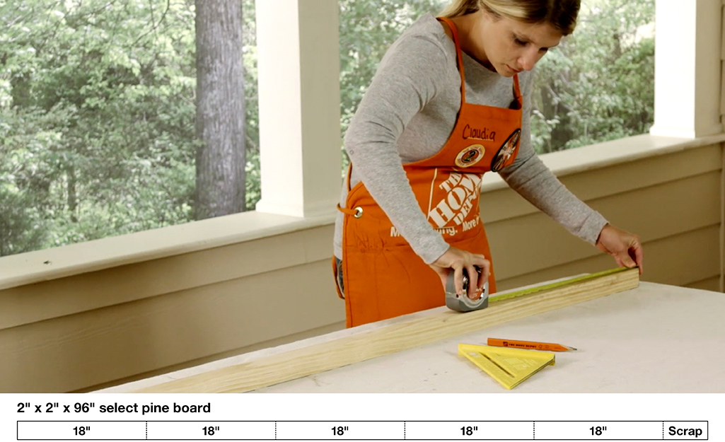 A woman uses a tape measure and a pencil to measure and mark the wood for the DIY Blanket ladder.