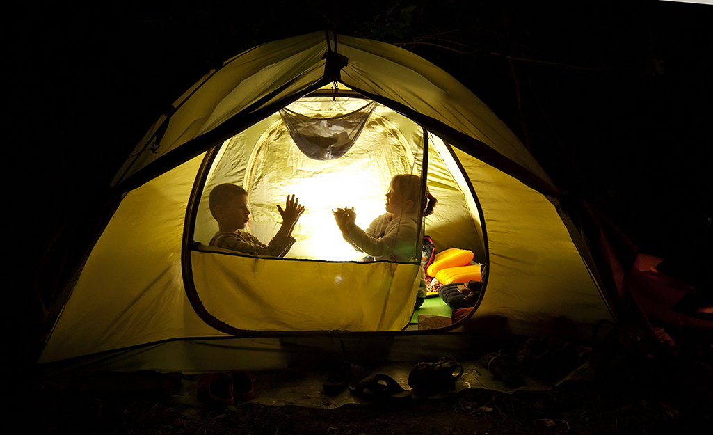 Kids playing in a tent at night.