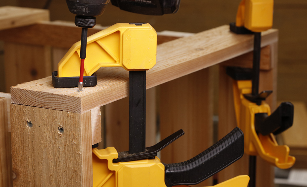 Clamps holding the sides of DIY compost bin together.