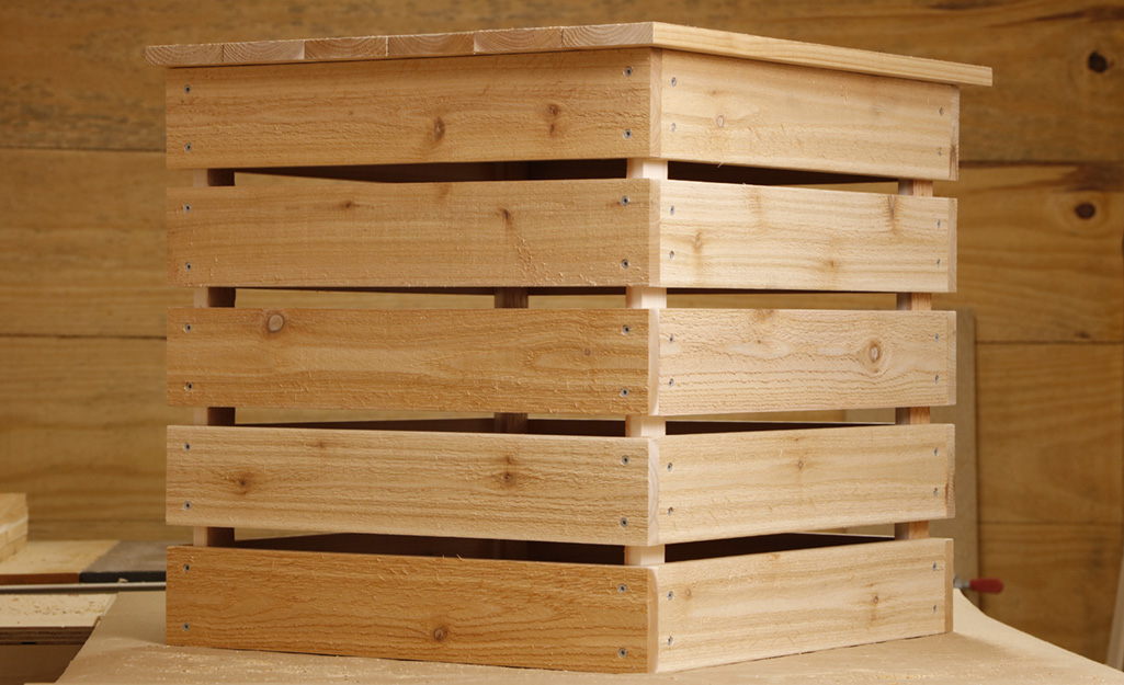 A completed DIY wood compost bin sitting on a table.