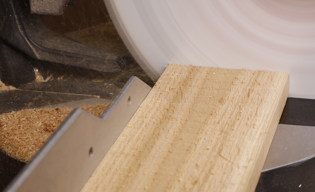 Someone cutting a cedar board with a saw.