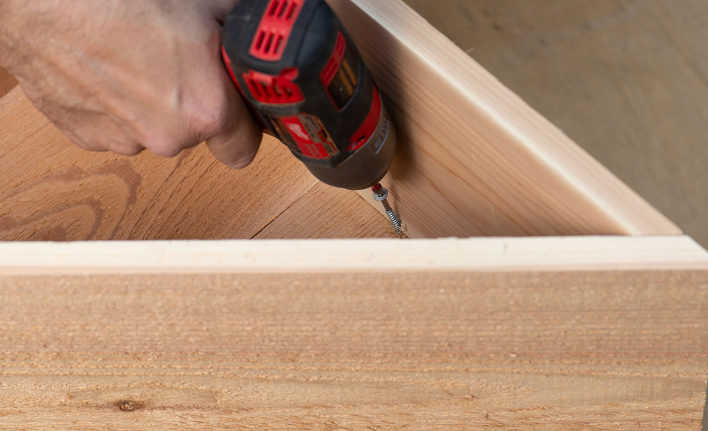 A small triangular tier secured on top of a larger one with a drill.