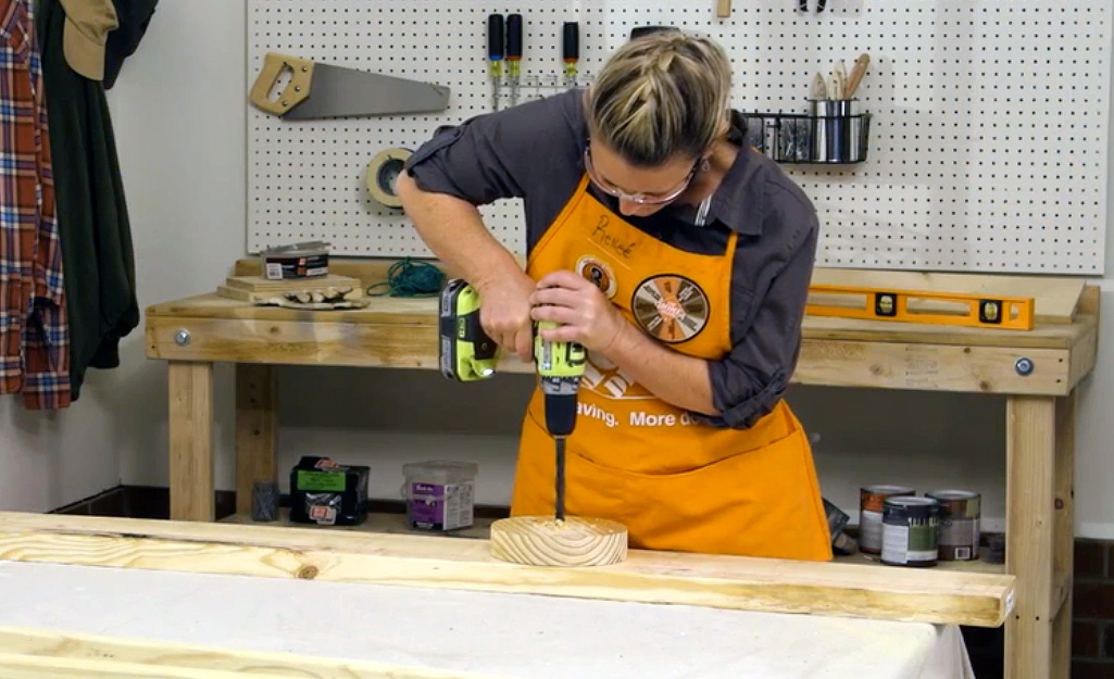 A person drilling into a baluster.