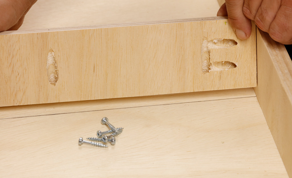 Screws are used to connect the pieces of the top of a DIY desk. Screws are used to connect the pieces of the top of a DIY desk.