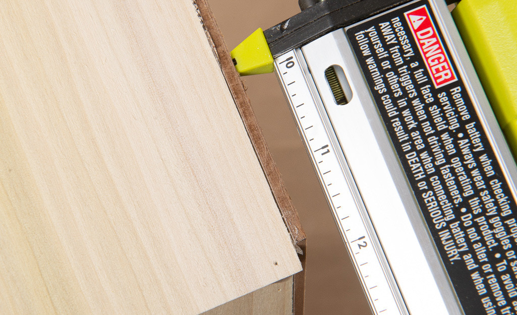 A nail gun being used to attach wood and backboard. A nail gun being used to attach wood and backboard.