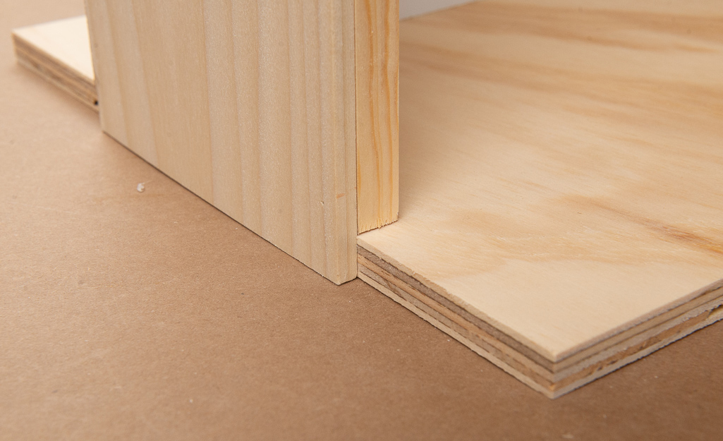 The base of the wooden dollhouse being attached. The base of the wooden dollhouse being attached.