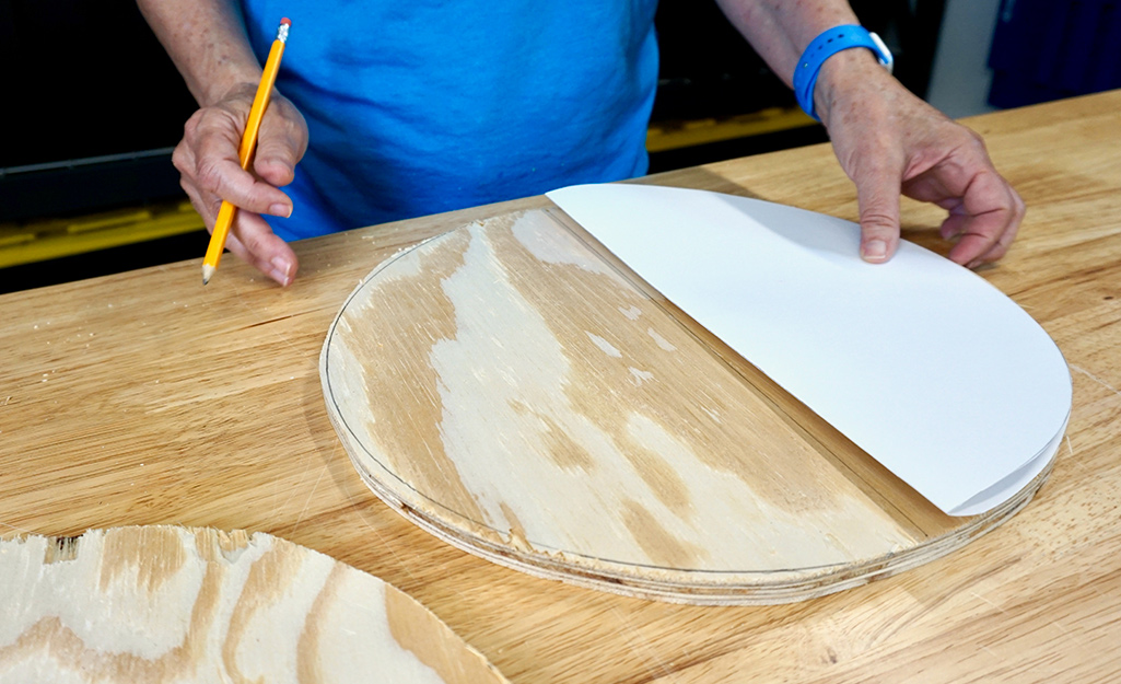 A person using a paper template to design the pumpkin. A person using a paper template to design the pumpkin.