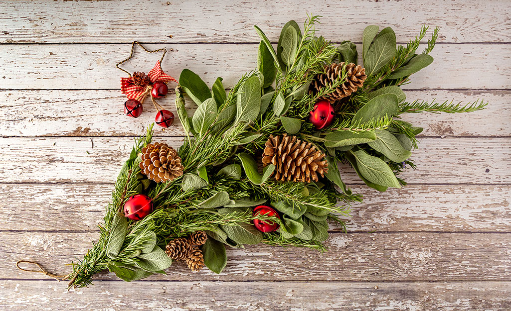 A spray of fresh herbs decorated with pinecones.