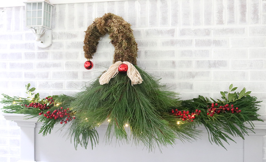 A mantel gnome made from pine, red berries and mini lights.