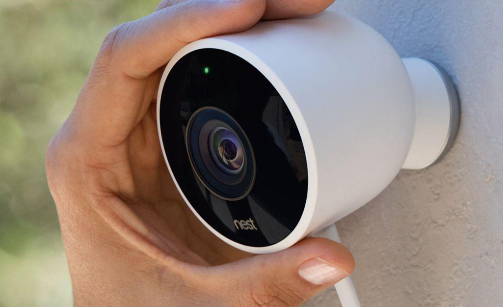 A person adjusting a wireless security camera.