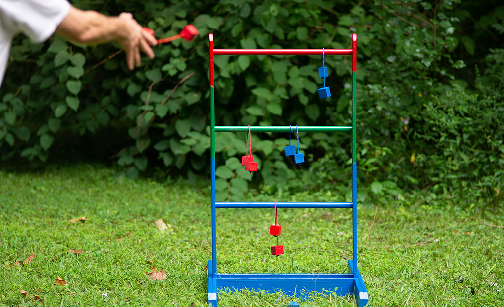 A person plays ladder golf outside.