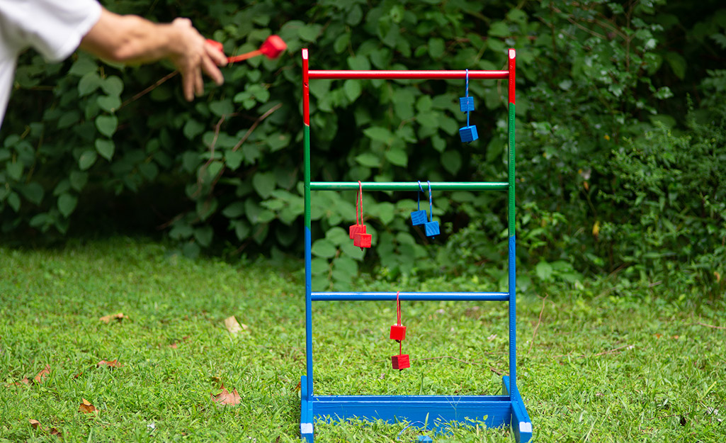 A person plays ladder golf. 