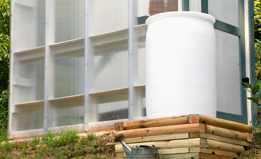A rain barrel set up for a test fit outside in a garden space.