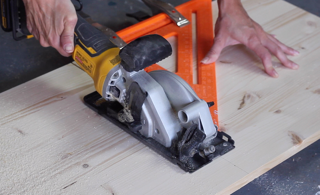 A saw cutting into a piece of wood.
