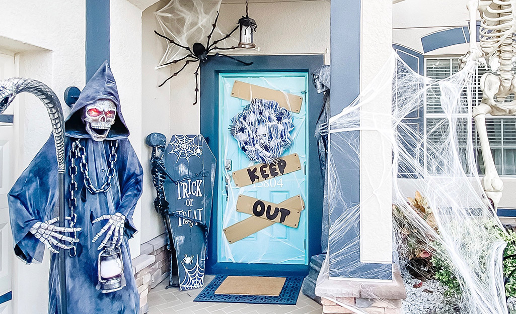 A front walkway decorated with cobwebs, skeletons and more.