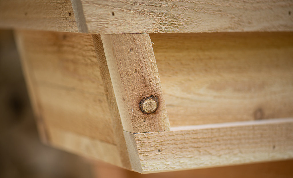 Pieces of wood serve as the trim on the edges of an angled DIY window box.