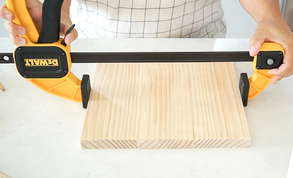 Person clamps the wood. Person clamps the wood.