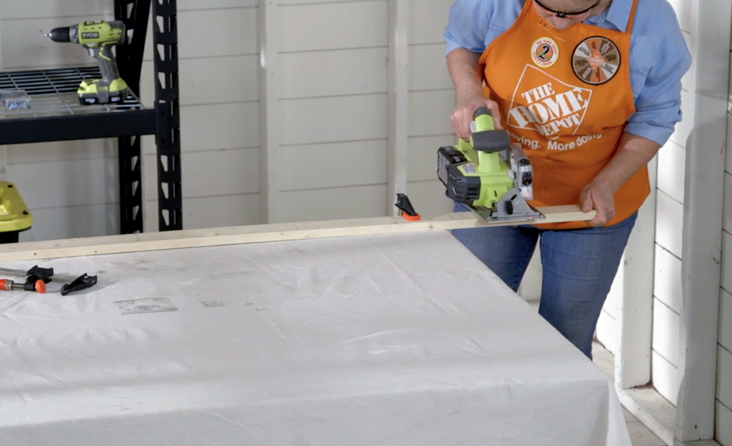 A person cuts wood with a hand saw.
