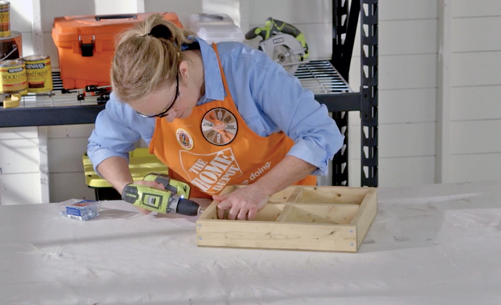 A person screws wood together.