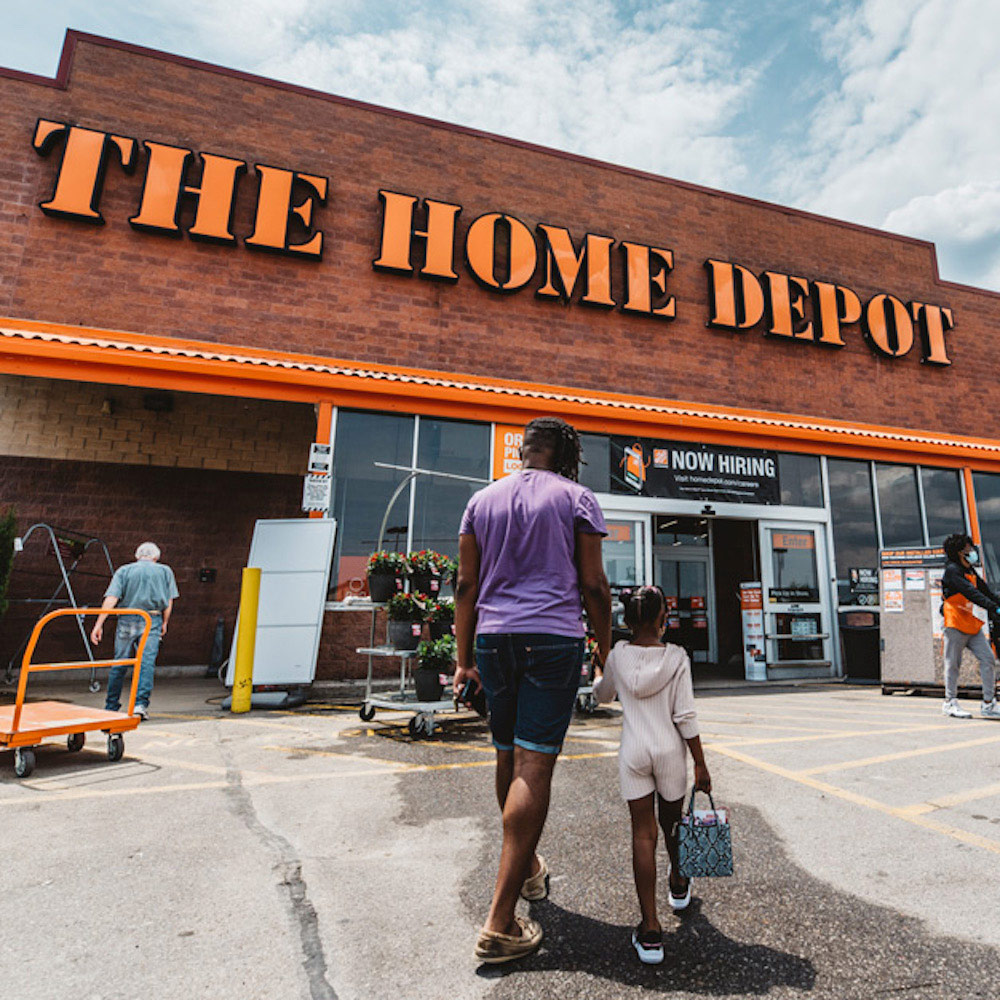 A man and little girl walking into The Home Depot.