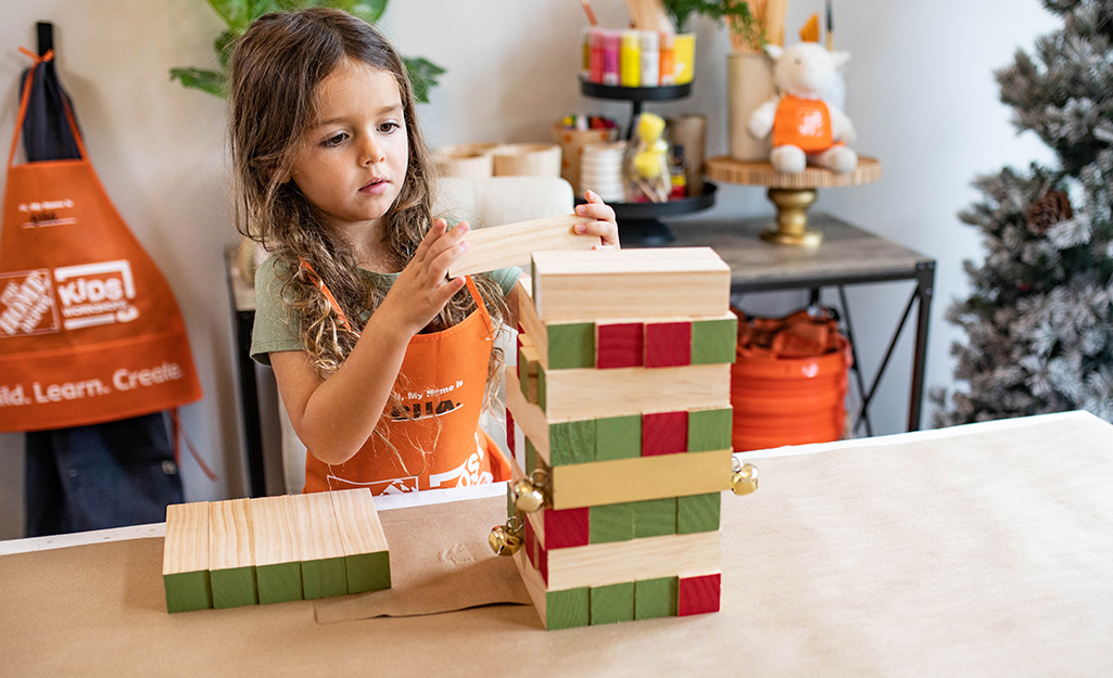 A child assembling the toppling tower game pieces.